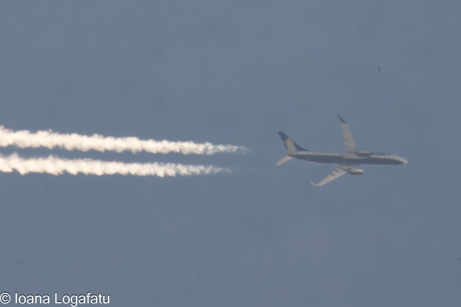 Plane soaring high with vapor trails